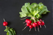 Ripe Bunch Organic Red Radish With Foliage On A Black Slate Dish As Background. Top View.