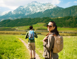 Canvas Print - happy couple with backpacks traveling in highlands