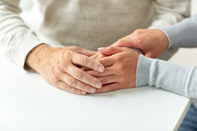 Close Up Of Old Man And Young Woman Holding Hands