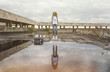 © Artem Markin - The blonde girl froze in a jump on the roof in front of a huge puddle. Blonde with long hair in a white T-shirt