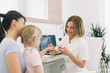 © cherryandbees - Best way to keep you teeth healthy. Mother and daughter at the dentist office. Dentist showing how to brush teeth.