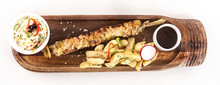 Pork Skewers Served With Baked Potatoes, Coleslaw Salad And Barbecue Sauce, Decorated With Radish, Red And Green Herbs, Placed On A Wooden Plate, Light Background, Isolated