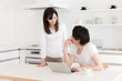 © taka - young asian couple relaxing in kitchen