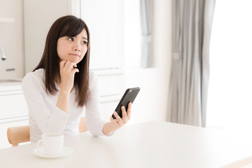 Canvas Print - young asian woman relaxing in kitchen