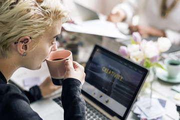 Sticker - Woman Sipping Coffee while Working on Laptop