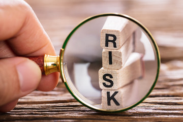person inspecting risk block with magnifying glass