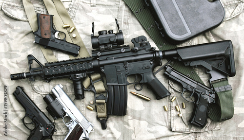 Fotomural Weapons and military equipment for army, Assault rifle gun (M4A1) and pistol on camouflage background