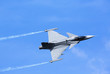 © Jne Valokuvaus - Modern jet fighter flying against a blue sky. White smoke trail.