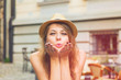 © Kitja - Young beautiful girl sending air kiss on the street.