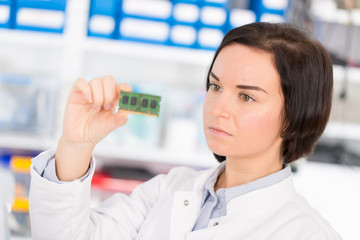 Poster - Female laboratory assistant Repairs PCB module for CNC robotics. Measurement of the parameters of the electronic system in the laboratory