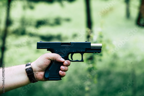 Zdjęcie XXL Pistolet jest w jego dłoni. Mężczyzna jest gotowy do strzału w cel.