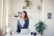 © chika_milan - Beautiful Caucasian girl standing in living room and using laptop in the morning
