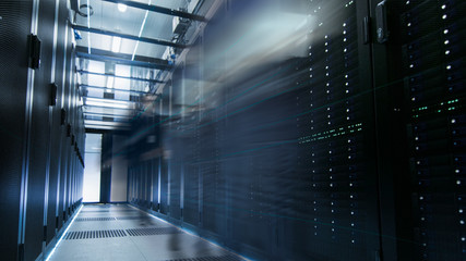 Wall Mural - Shot of a Working Data Center With Rows of Rack Servers. People Walk and Work there, they are Blurred in Motion. Long Exposure Shot.