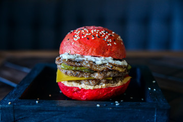 Red burger on a wooden board