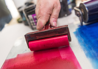 an acrylic paint roller for mono printing and screen printing, rolling paint ready for mono printing.