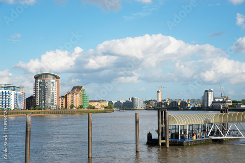 Foto Wide river canal, city skyline, residential buildings on the other side of the s
