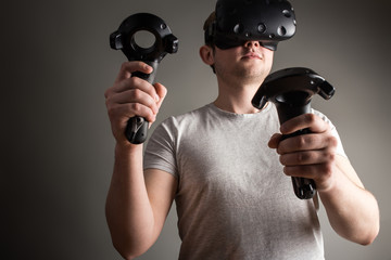 man using the virtual reality glasses and two gamepad