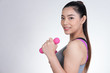 © 88studio - Young asian sporting woman training with dumbbell. Pretty athletic girl making physical exercise against white background. Healthy lifestyle concept.