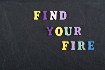 FIND YOUR FIRE word on black board background composed from colorful abc alphabet block wooden letters, copy space for ad text. Learning english concept.