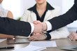 © rogerphoto - Close up of business people shaking hands at meeting or negotiation in the office. Partners are satisfied because signing contract