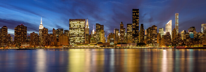 Wall Mural - Panoramic view of Midtown East skyscrapers from the East River at twilight. Manhattan, New York City