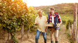 © luckybusiness - Family in vineyard celebrating harvesting grapes.