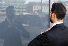 Businessman Standing Outside And Looking At His Reflection In Window
