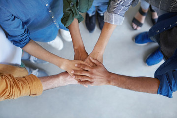 Solidarity and unity conept. Cropped shot of business partners holding their hands together expressing their agreement. True friends keeping their hands together swearing always help each other