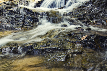 beautiful nature,cascaded tropical river flowing through over wet rock at sunny day