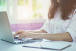 © mansong - Portrait of beautiful smiling young Engineering woman sitting at home office desk working on laptop, focusing on project. Attractive cheerful model using computer. In office.selective focus