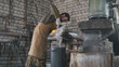 Blacksmith manually temper steel knife in engine oil