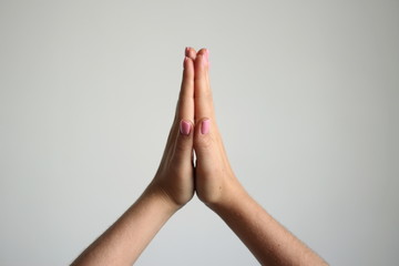 Young woman's hand isolated on light gray backgrond gesture of prayer