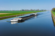 canvas print picture - Mit Kohle beladenes Frachtschiff auf dem Schleusenkanal in der Wesermarsch