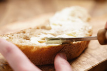 Young Female Hands Spreading Butter On Bread