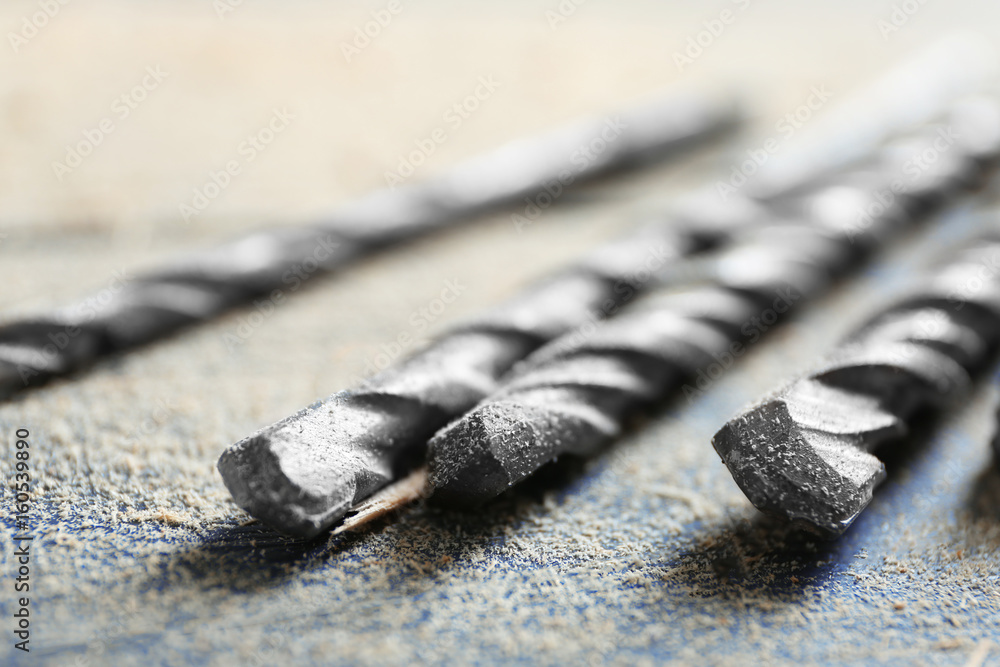 Set of drills on wooden table, closeup