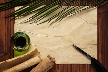 Wall Mural - white goose feather and inkwell, scroll on the background table