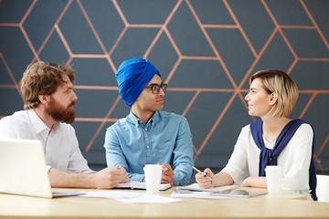 Group of young newsreaders discussing fresh news