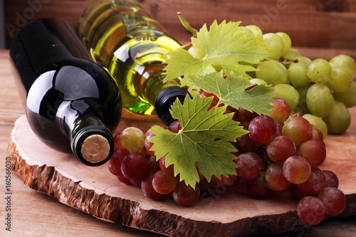 butelka-bialego-i-czerwonego-wina-obok-winogron-na-drewnianym-stole