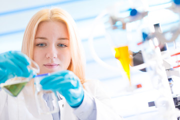 Poster - Female laboratory assistant with chemical experiment in scientific laboratory