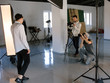 © Photodrive - Professional photo and video production team work together. Two photographers taking shots of male model in studio. Fashion photoshooting backstage