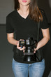 © Photodrive - Female photographer and black camera. Unrecognizable young woman photographing something with professional equipment in studio