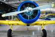 Front view of restored, stationary propeller aeroplane, indoors, at day.