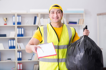 Wall Mural - Man cleaning the office and holding garbage bag