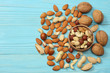mix almonds, cashew nuts, hazelnut, peanuts, walnuts, pistachio on wooden background. Top view with copy space