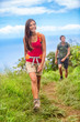 Happy woman hiker hiking couple in nature trek on hike trail on summer travel vacations. Healthy lifestyle young Asian girl smiling enjoying walk with man.
