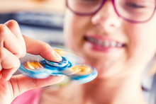 Fidget Spinner. Cute Young Girl Playing With Fidget Spinner.