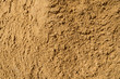 Texture of the sand. Background Industrial sand for construction works. Natural material for bricks and concrete products - loose rock, which grains of feldspar, mica, quartz and other minerals.