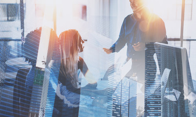 Teamwork process.Young team of businessmans making great business discussion in modern coworking office.Double exposure,skyscraper building blurred background.Horizontal.Flares effect.