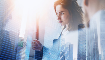 Wall Mural - Group of businessmans on meeting.Business team at working process.Closeup view of young woman giving business card to partner.Double exposure,skyscraper building blurred background.Flares effect.