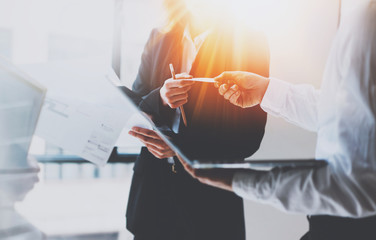 Wall Mural - Group of businessmans on meeting.Business team at working process.Young woman giving business card to partner.Blurred background.Horizontal.Flares effect.